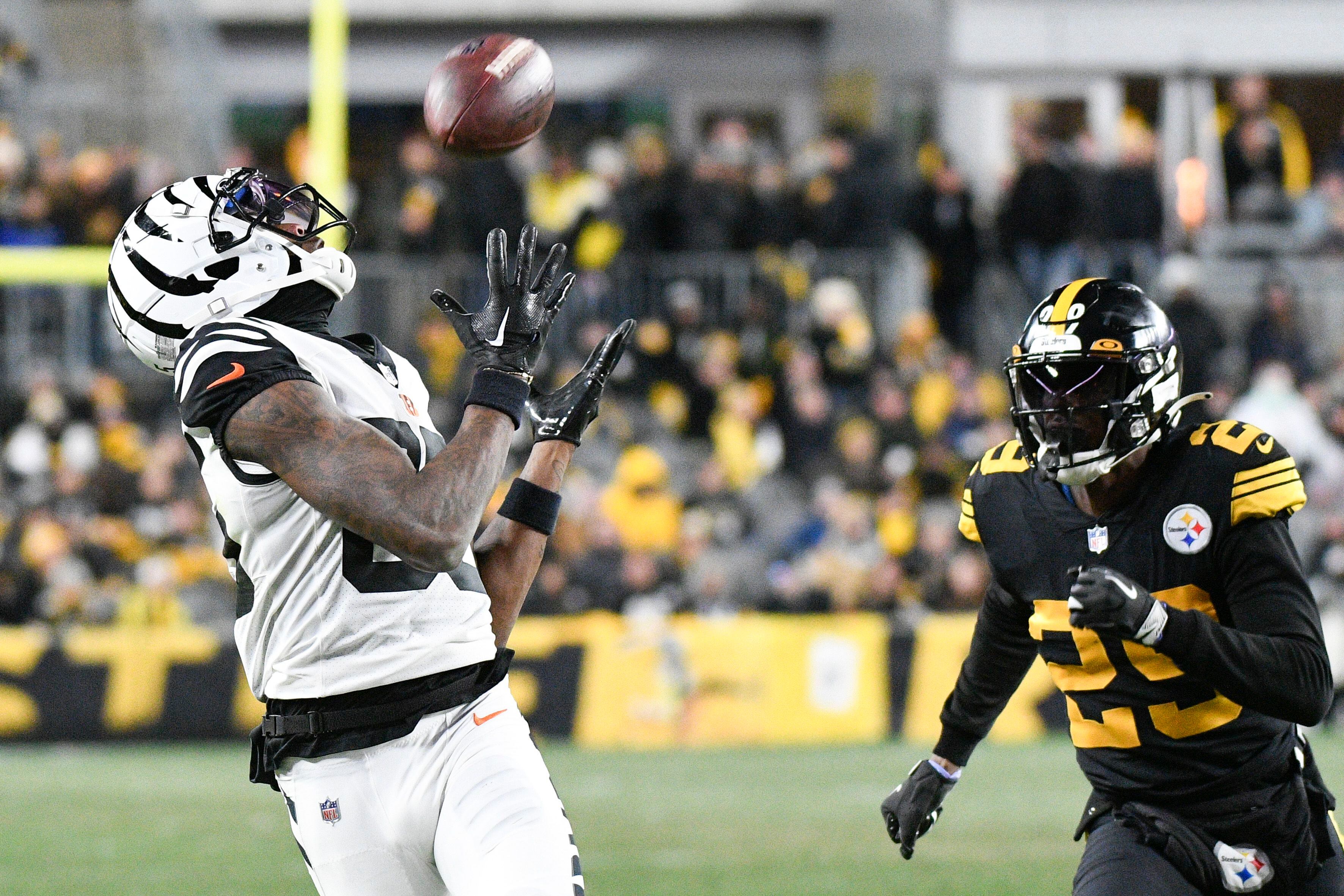 Cincinnati Bengals quarterback Joe Burrow hits wide receiver Tee Higgins in  stride over the middle for first down and then some