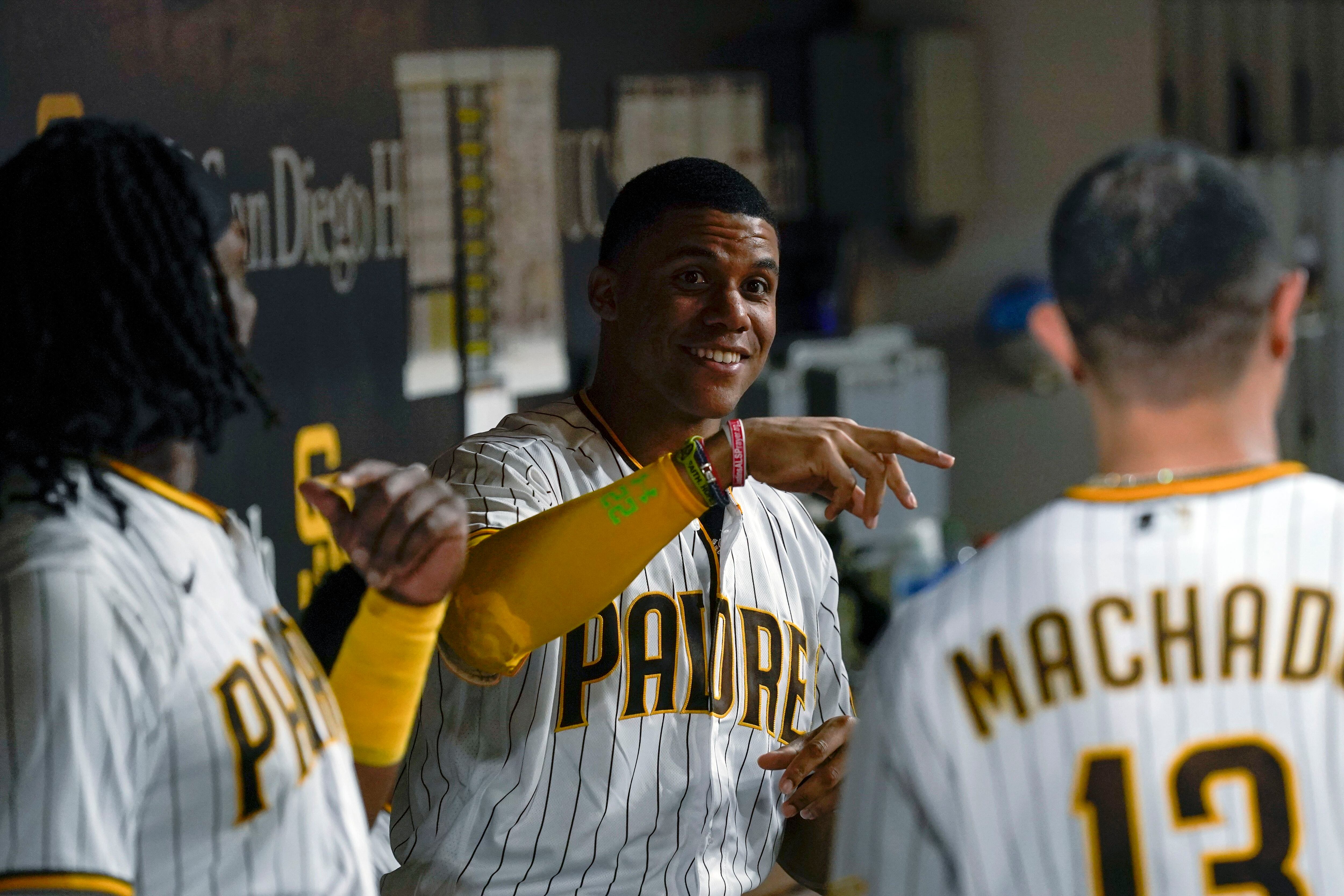 San Diego Padres' Juan Soto, right, heads for the dugout after flying out  to end the baseball game, as Colorado Rockies celebrate a Padres 7-3 win  Thursday, Aug. 4, 2022, in San