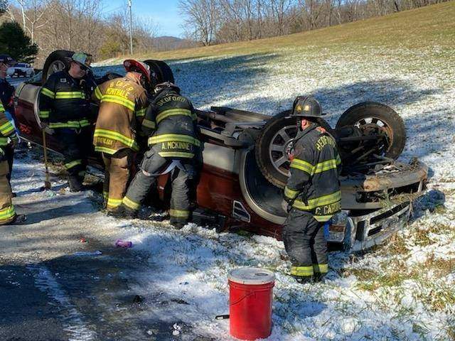 One injured, three children unharmed following pickup overturning in Bedford